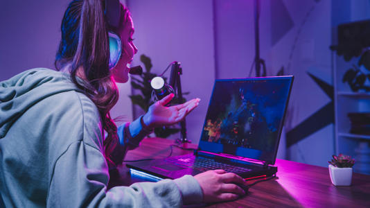 a young woman gaming on a laptop