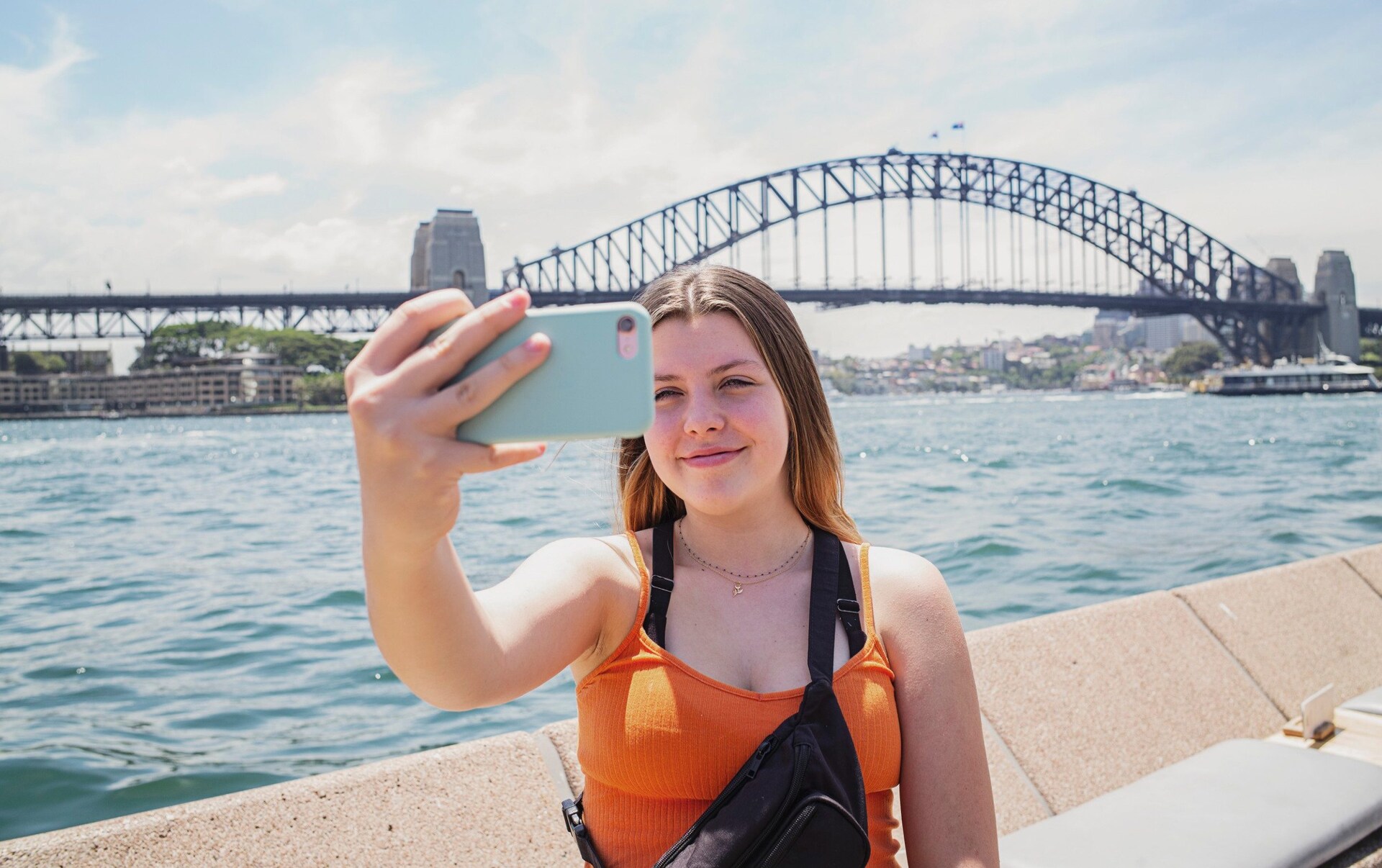 Teenage girl taking selfie by Sydney Harbour Bridge