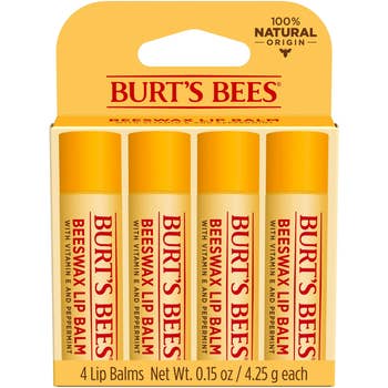 Pack of four Burt's Bees lip balms, labeled with beeswax, vitamin E, peppermint, and 100% natural origin