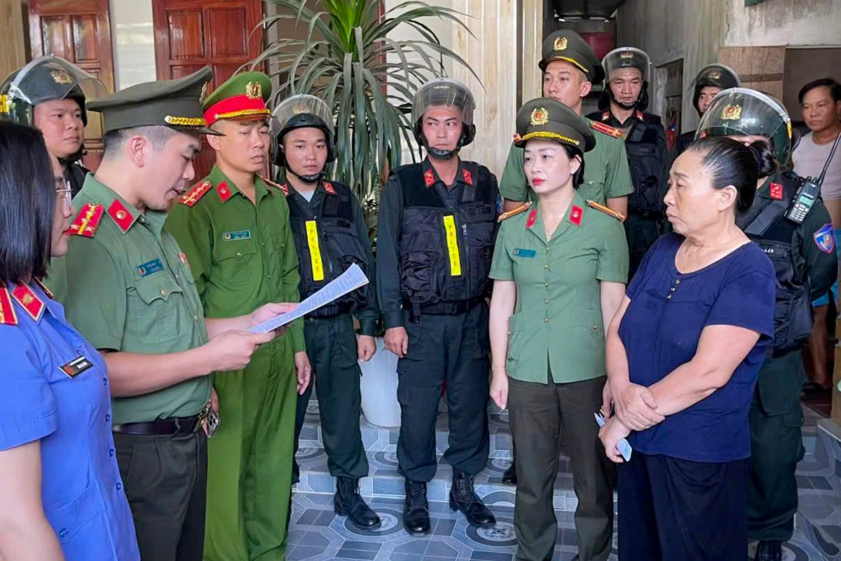 Bà Lê Thị Thủy (ngoài cùng, góc phải), nghe cơ quan điều tra đọc lệnh khởi tố, sáng 25/6. Ảnh: Tân Châu