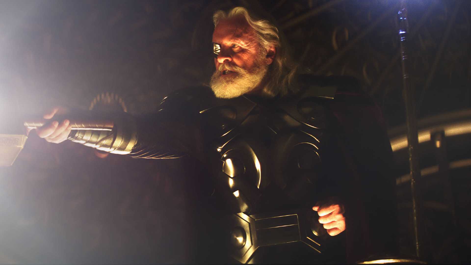 Anthony Hopkins as Odin in Thor, wearing a black suit with a gem over his eye.