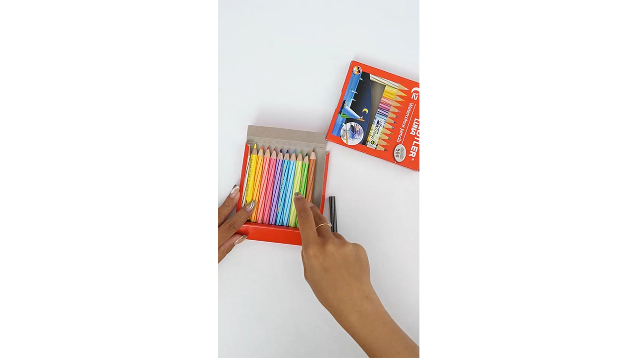 Arranging rainbow colored pencils into a neat storage box