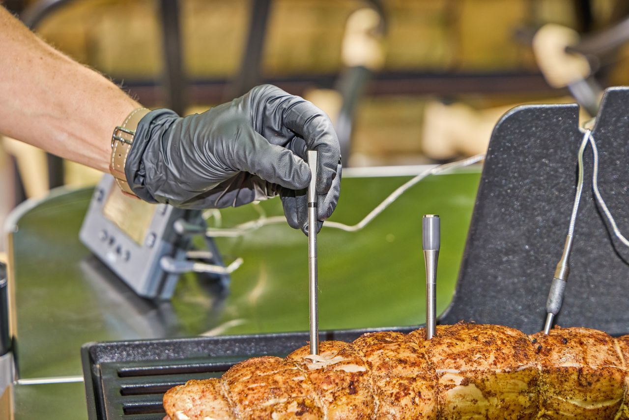 A person uses the MEATER Pro 2 Plus Wireless Bluetooth Smart Meat Thermometer