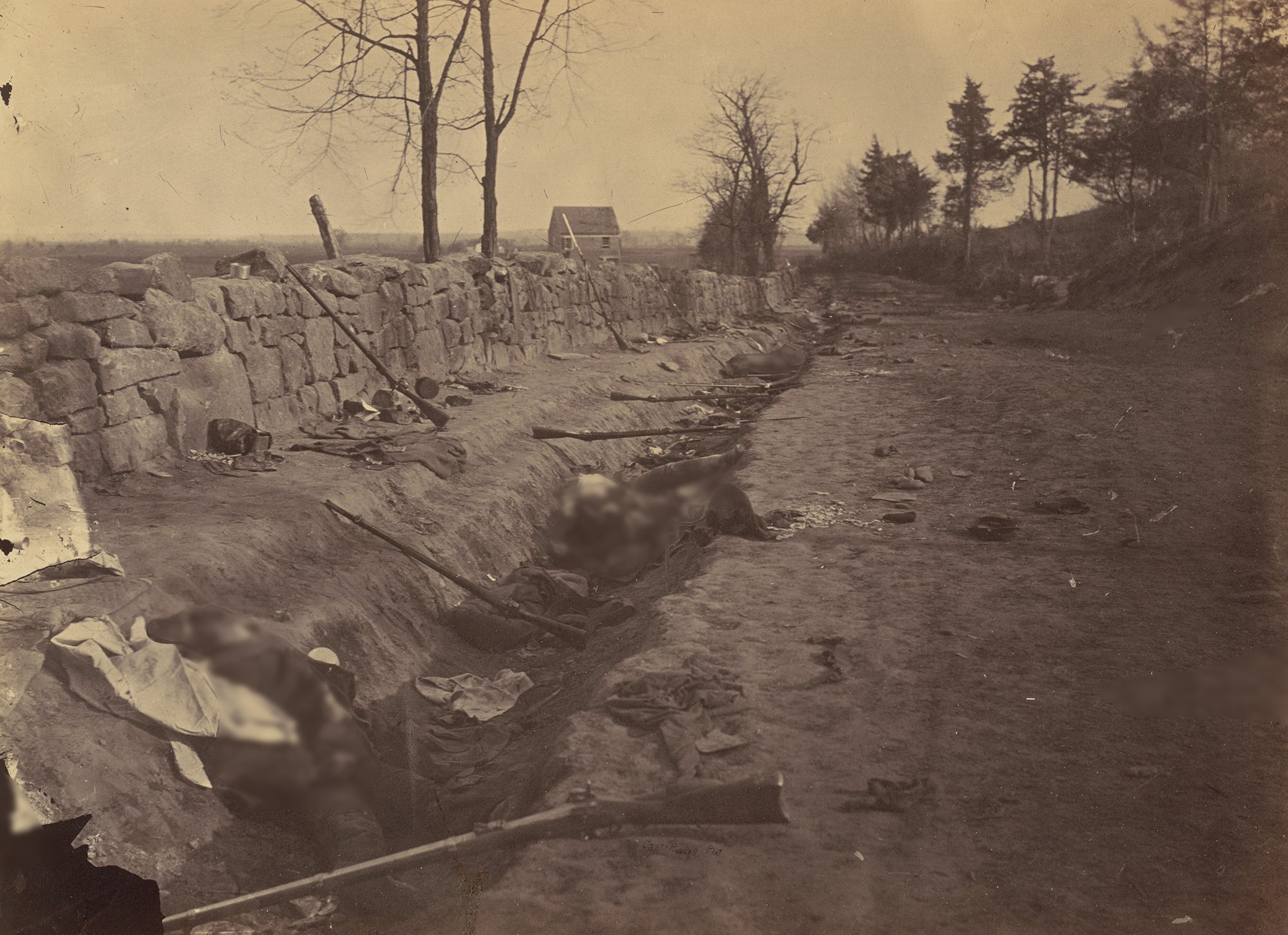 Rifles abandoned at a trench beside fallen soldiers at the Battle of Fredericksburg during the Civil war.