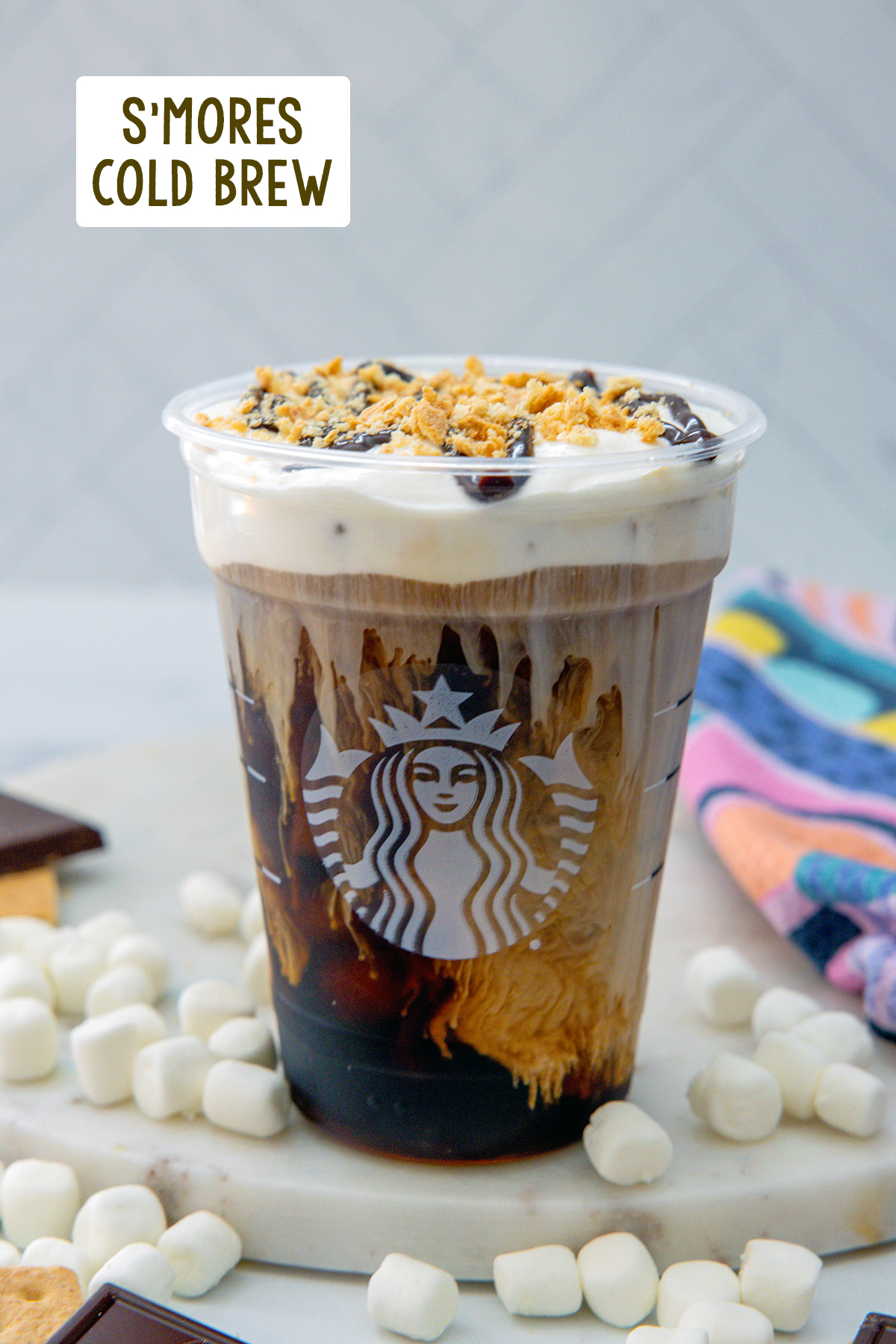 Head-on view of a s'mores cold brew topped with chocolate drizzle and graham cracker crumbs with recipe title at top.