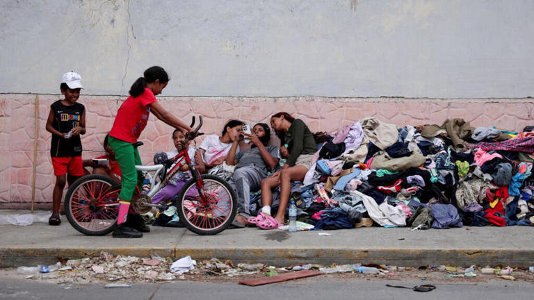 Niños que perdieron sus hogares en los terremotos descansan sobre un montón de ropa donada en una calle de La Guaira, Venezuela, el 29 de junio de 2026.