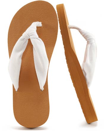 Two sandal-style flip flops with thick, white fabric straps and simple soles