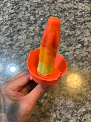 hand holding a popsicle in the holder