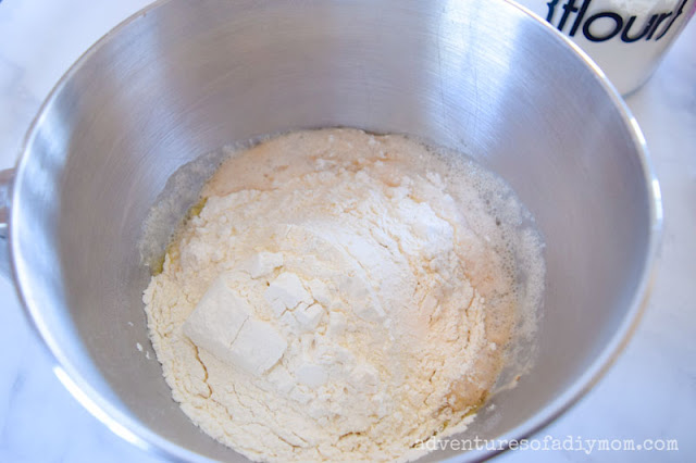 adding flour to dough for raspberry rolls