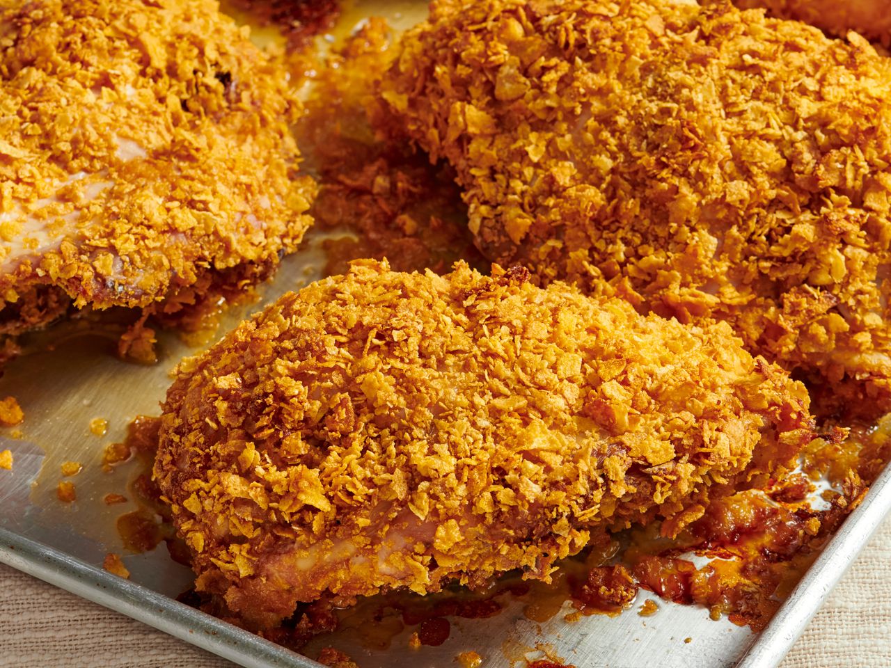 Baked cornflakecoated chicken breast on a baking tray