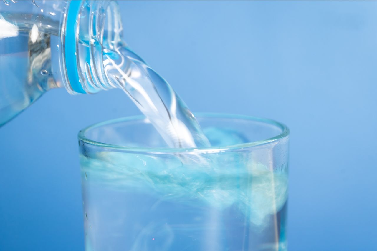 Water being poured from a plastic bottle into a glass