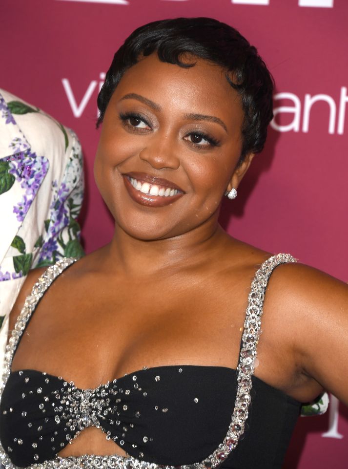 A person posing and smiling at an event