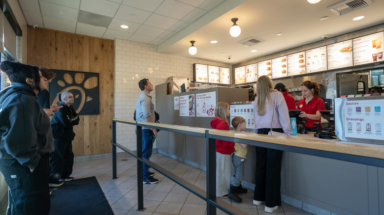 People placing orders at counter at a Chick-fil-A