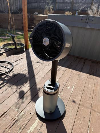 Portable pedestal fan on a wooden deck, suitable for indoor and outdoor use