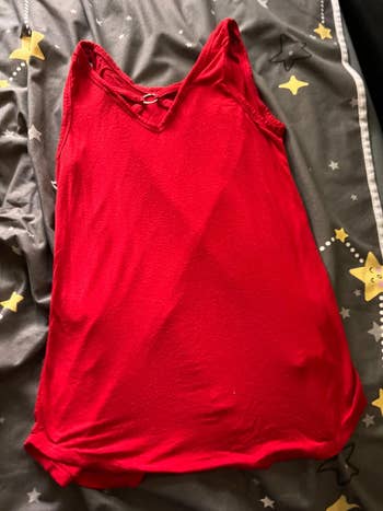 Red spaghetti strap dress with a V-neckline laid on a bed with a star-patterned blanket