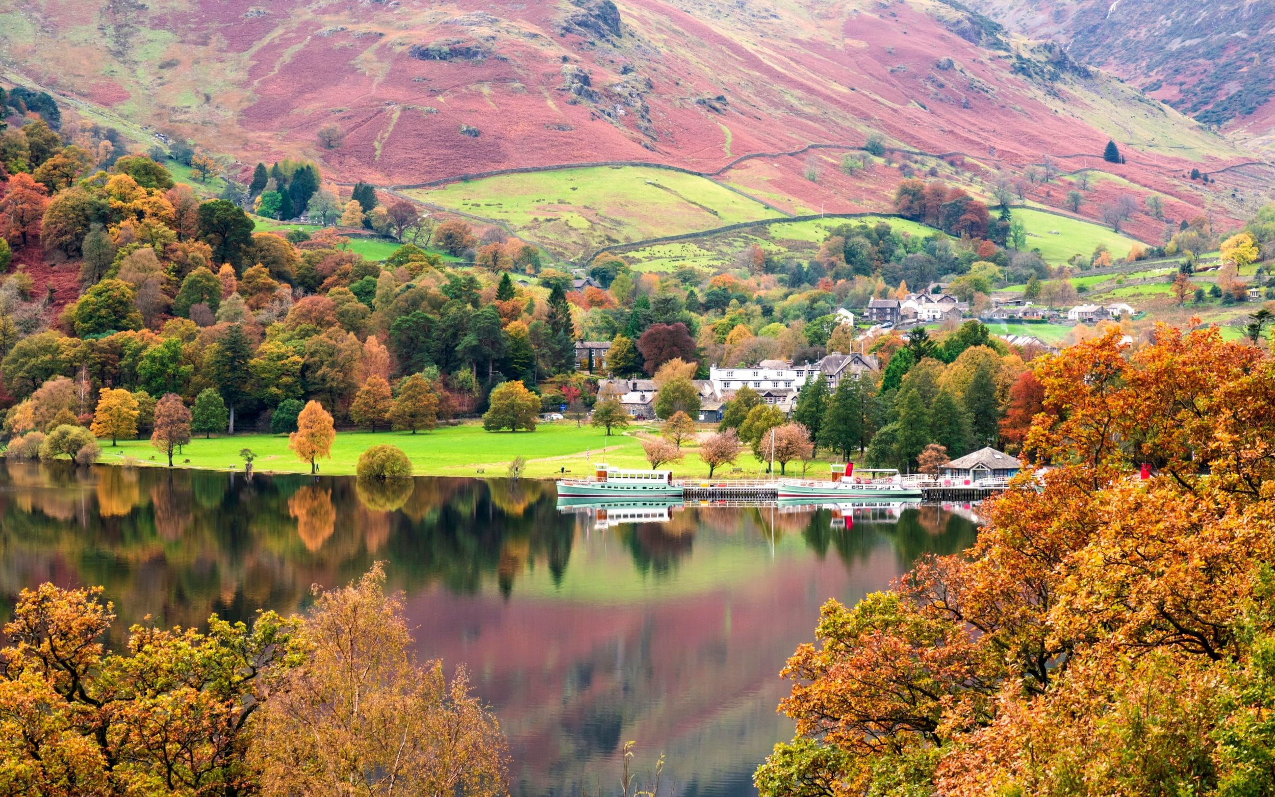 Steamer boats and autumn scenery reflected on Ullswater in the Lake District