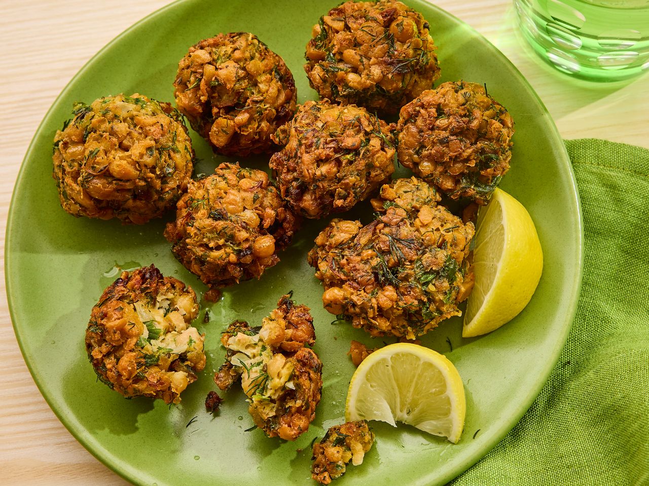 Plate of fried chickpea fritters with lemon wedges on the side