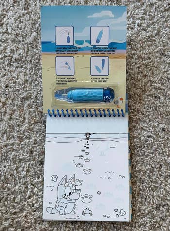 Children's water-reveal coloring book with a refillable water pen and beach-themed illustrations on the cover