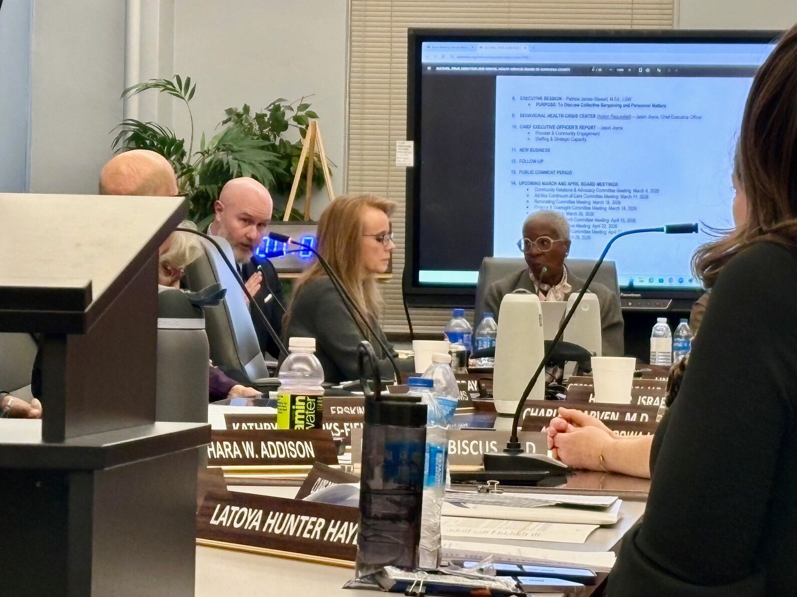 Cuyahoga County Alcohol, Drug Addiction and Mental Health Services Board (ADMAHS Board) CEO Jason Joyce debates spending priorities as Board of Directors Chair Patricia James-Stewart looks on at the head of the table during the Feb. 25, 2026, meeting.