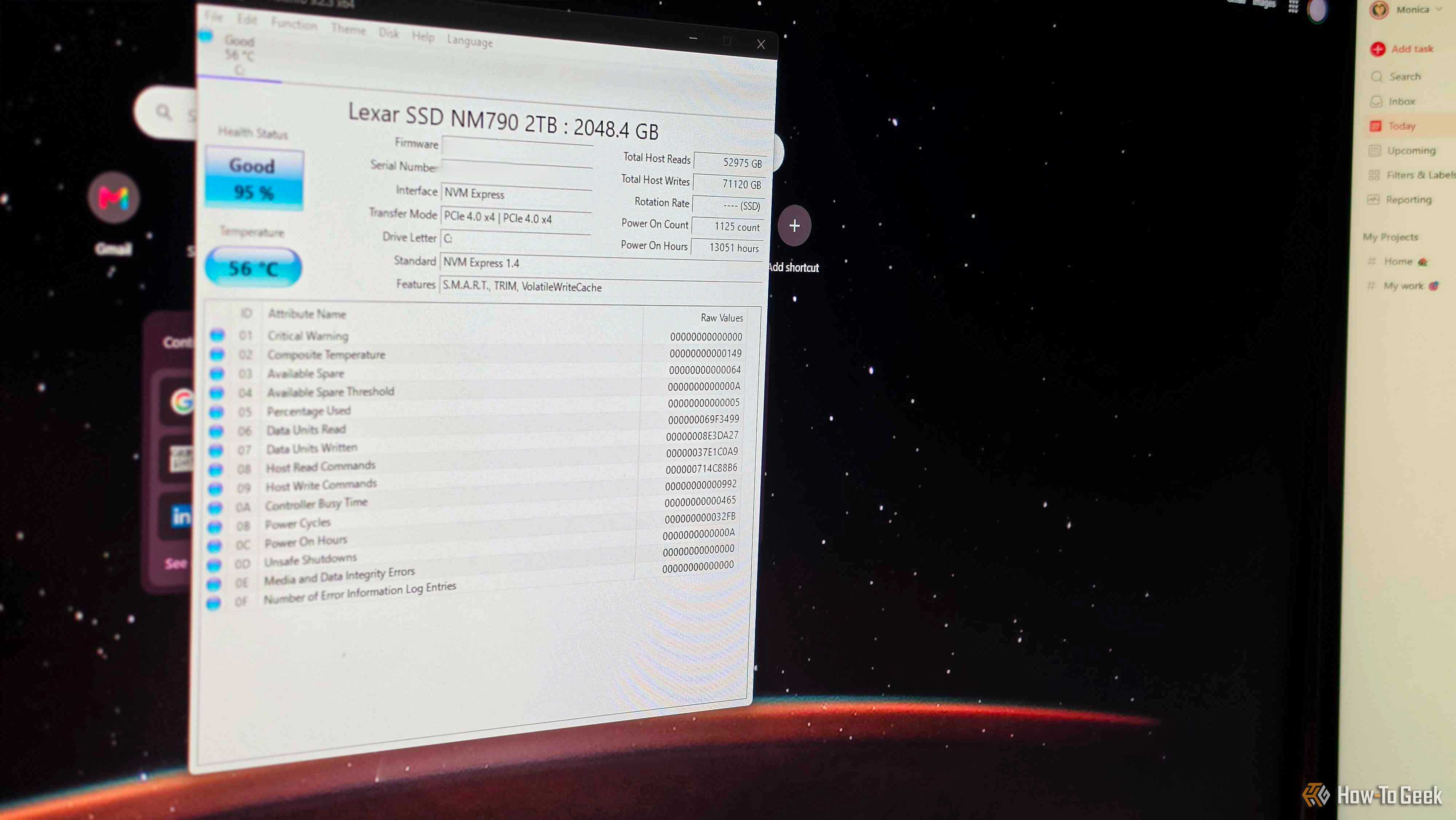 CrystalDiskInfo on a computer monitor, with another monitor next to it.