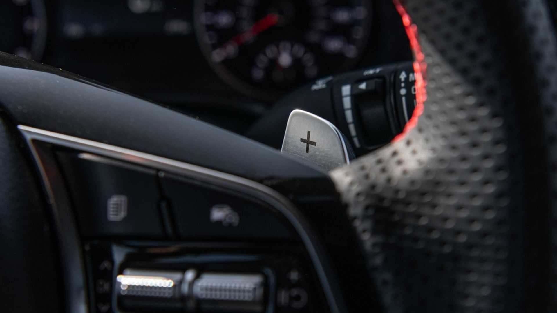 Close-up shot of the gear shift paddle behind the steering wheel of a 2022 Kia Forte.