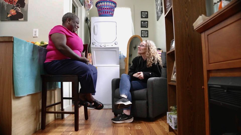 Rhea Holmes, left, visits with a team member from A Tiny Home for Good - CNN