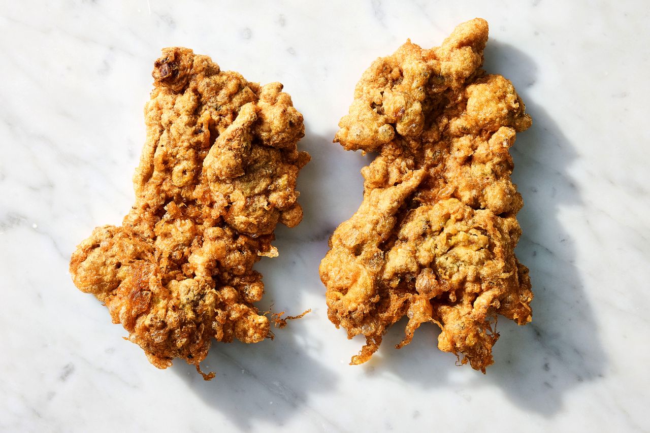 Two pieces of fried chicken on a marble surface