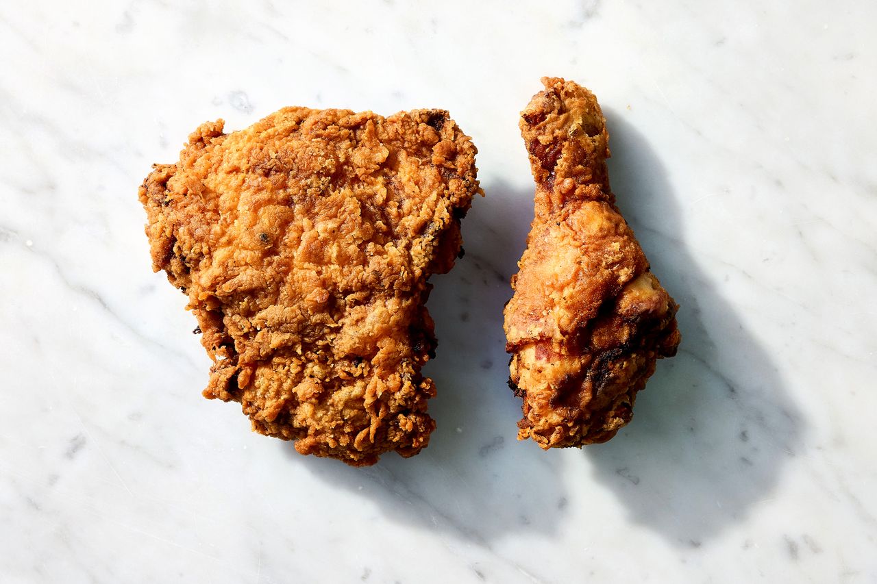 Fried chicken breast and drumstick displayed on a marble surface