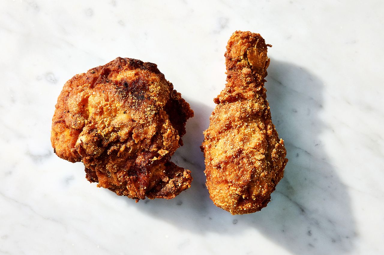 Two pieces of fried chicken placed on a marble surface