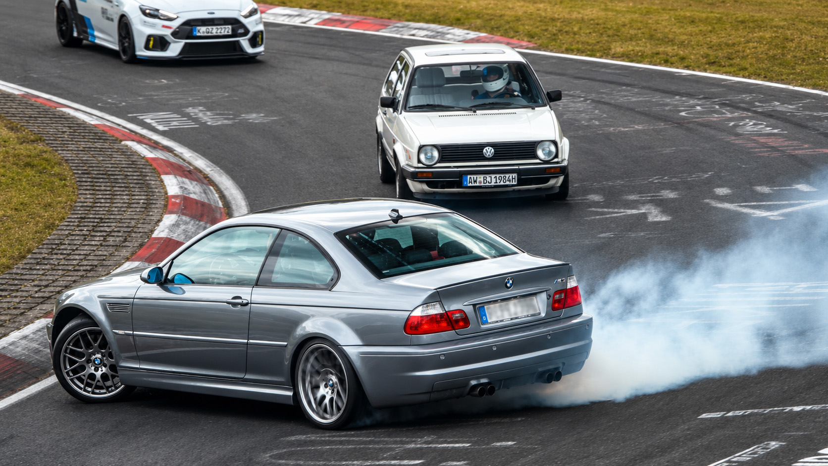 BMW driver slides off mid corner creating a dangerous close call