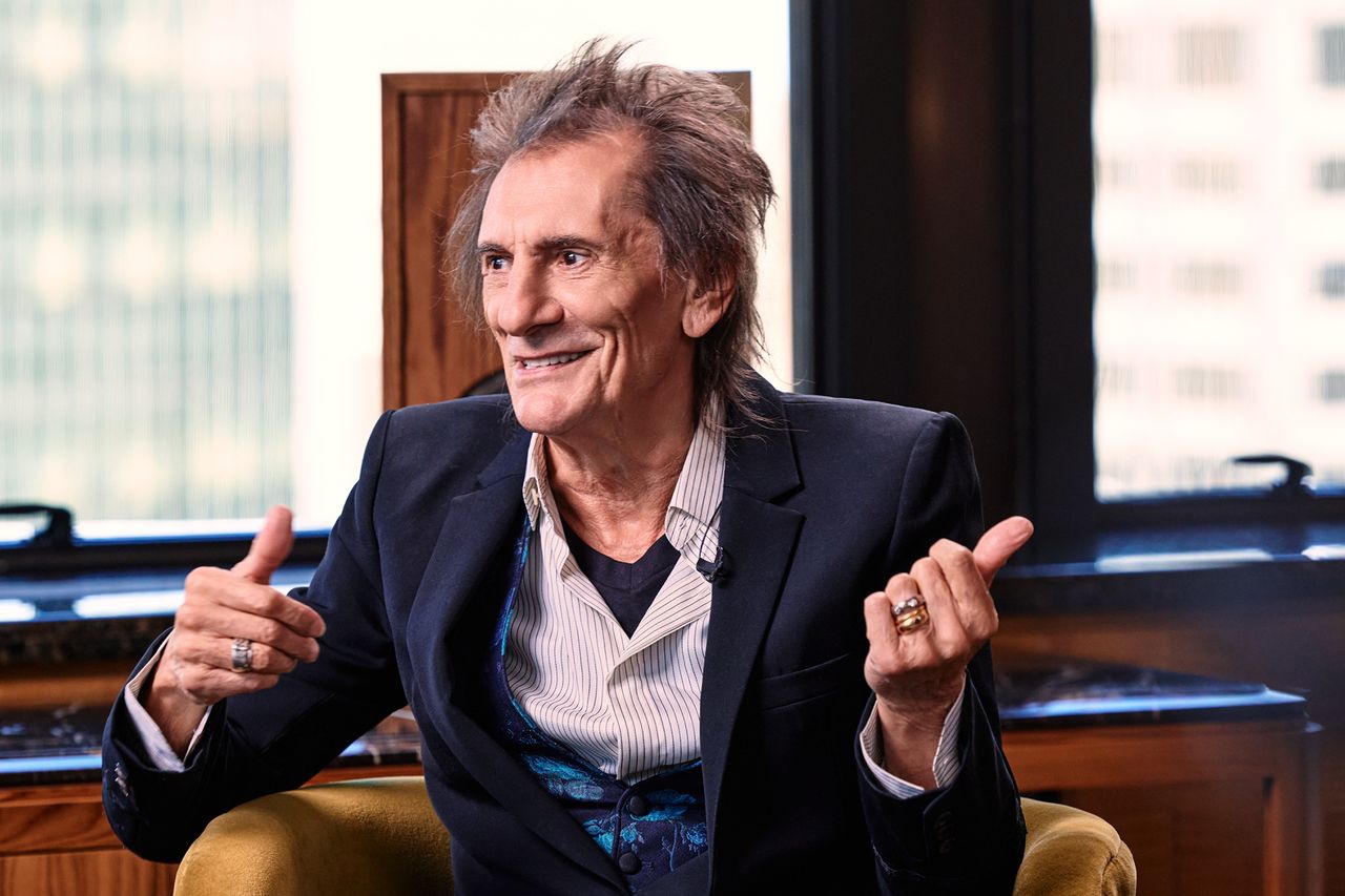 Ronnie Wood gesturing while seated indoors