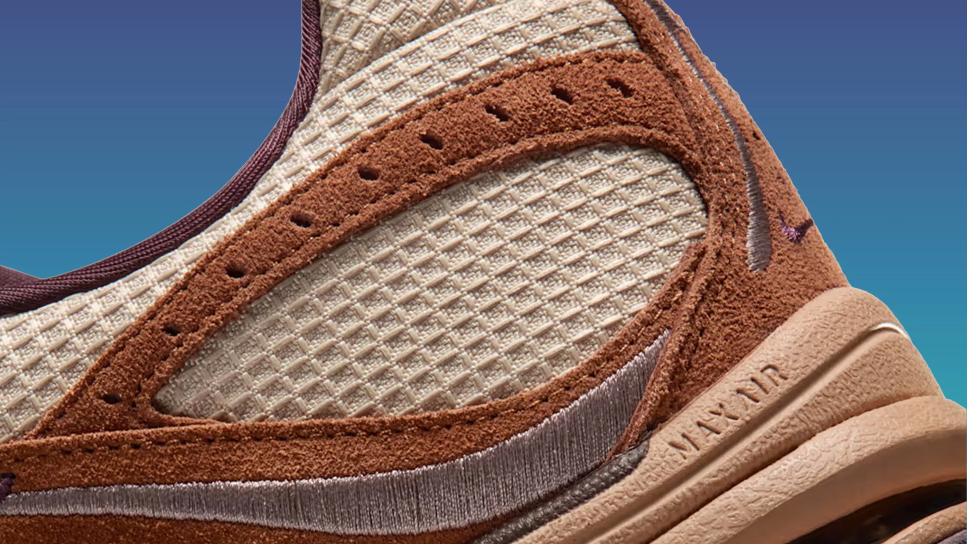 Close-up of a brown suede and beige mesh Nike Air Max sneaker with visible stitching and textured sole.