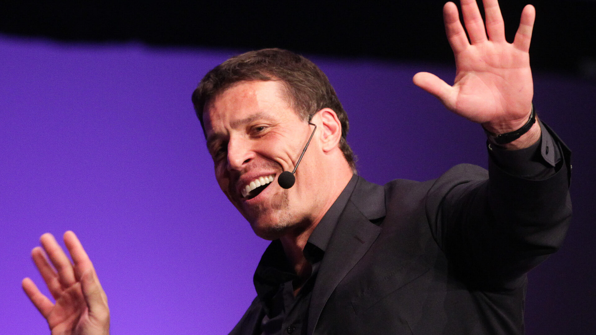 Discover financial expert and popular life coach Tony Robbins excitedly speaking at a seminar