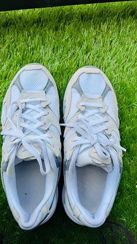 The same pair of sneakers, now clean and stain-free, against grass