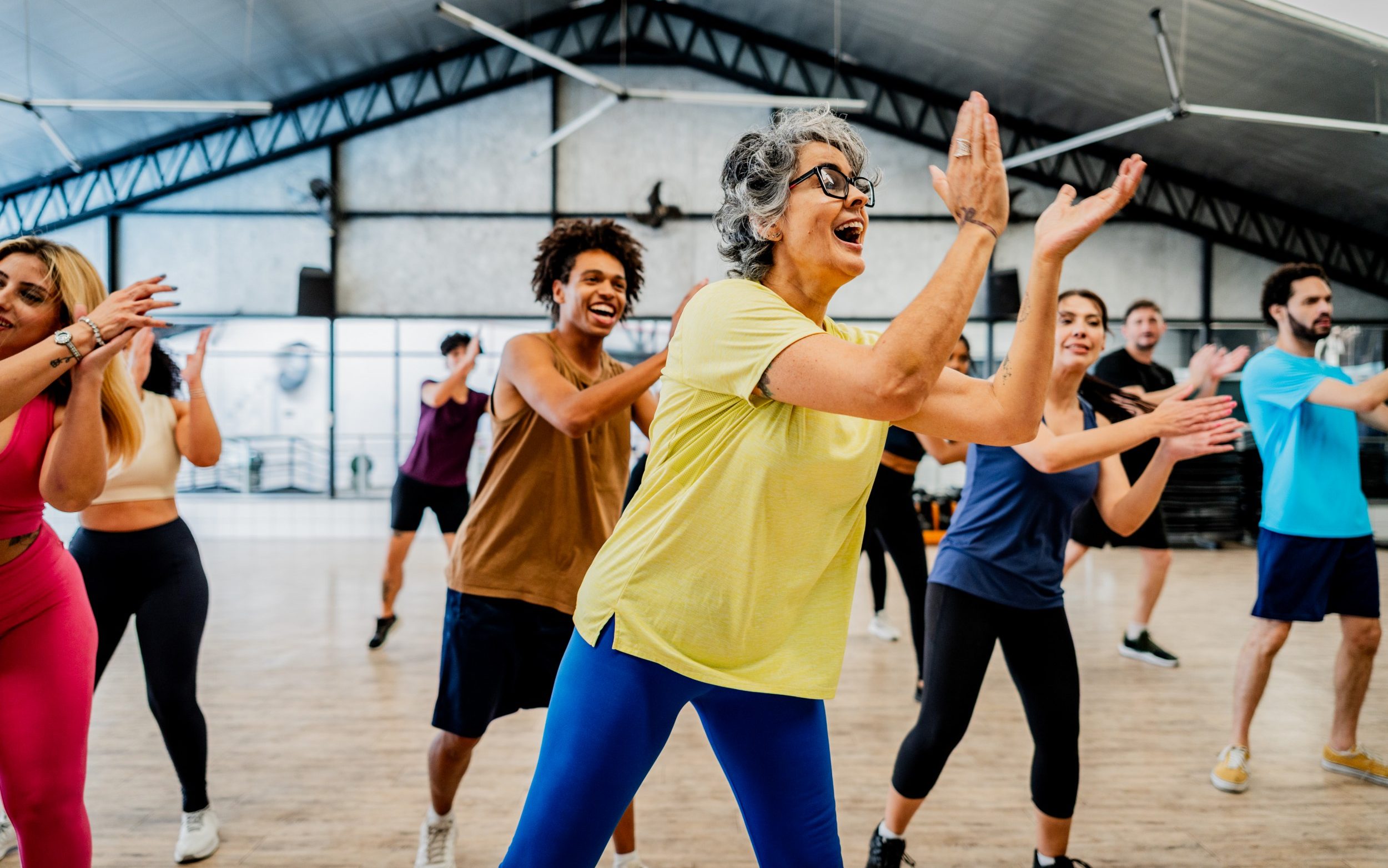 A group of women of different ages and ethnicities take part in a dance class in a fitness centre