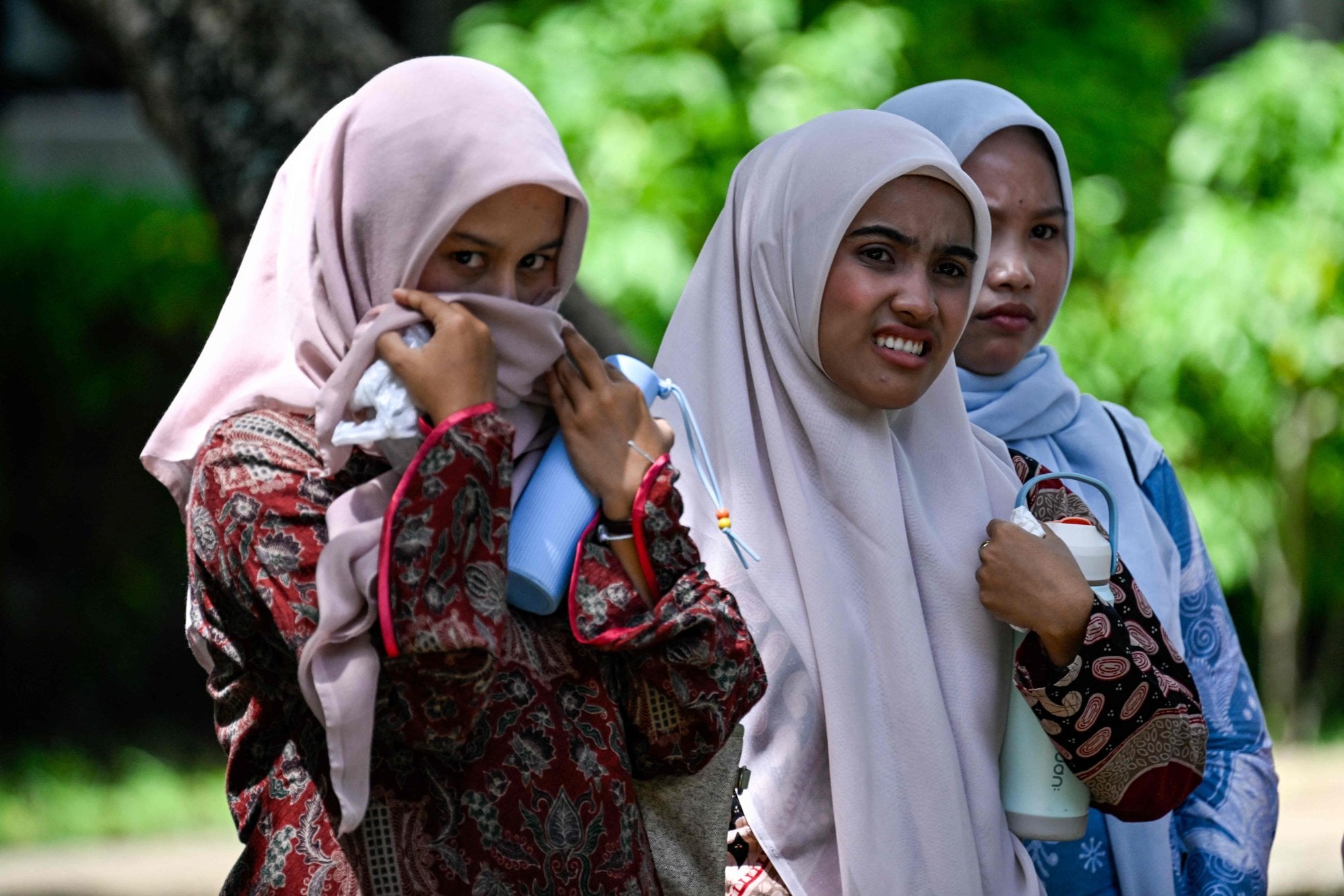 Women react as they watch the young couple receive a public caning in Banda Aceh on July 2. Views on caning vary in the province. Photo: AFP