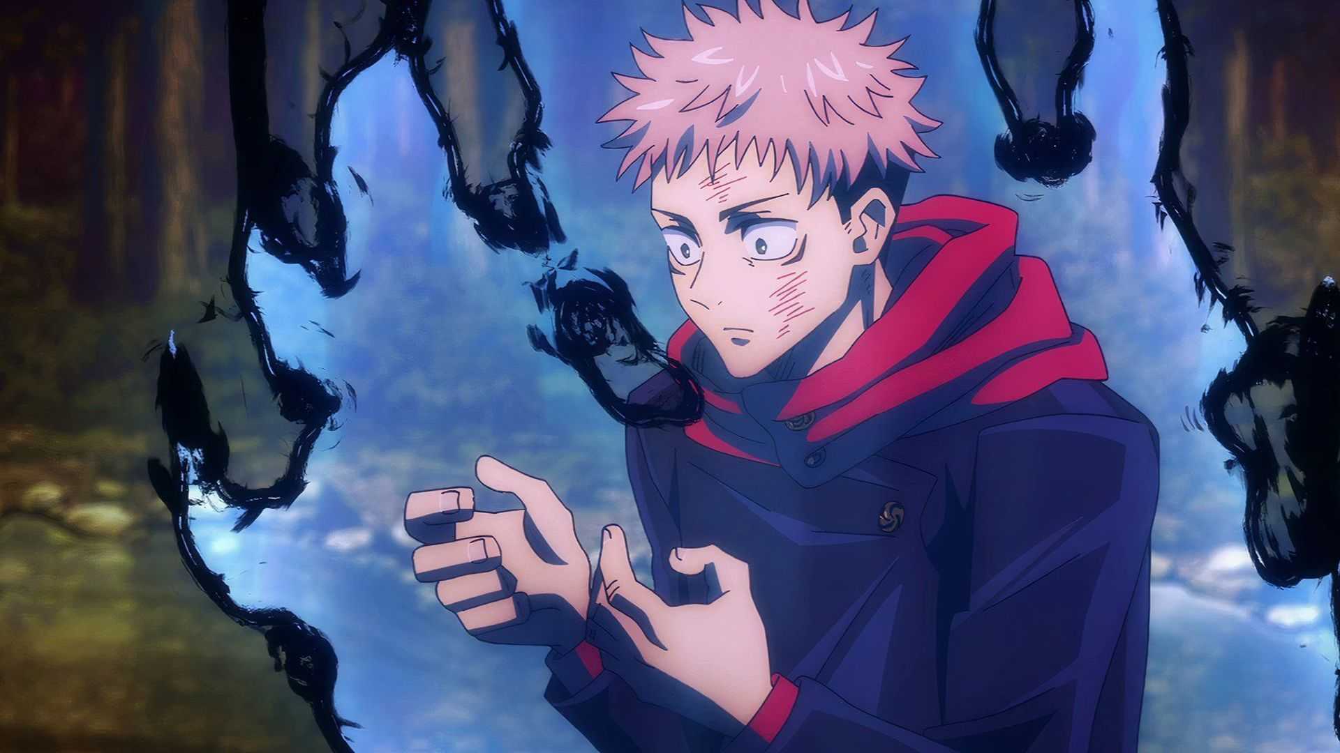 Yuji Itadori looks down at his hands in Jujutsu Kaisen as cursed energy flares up around him.