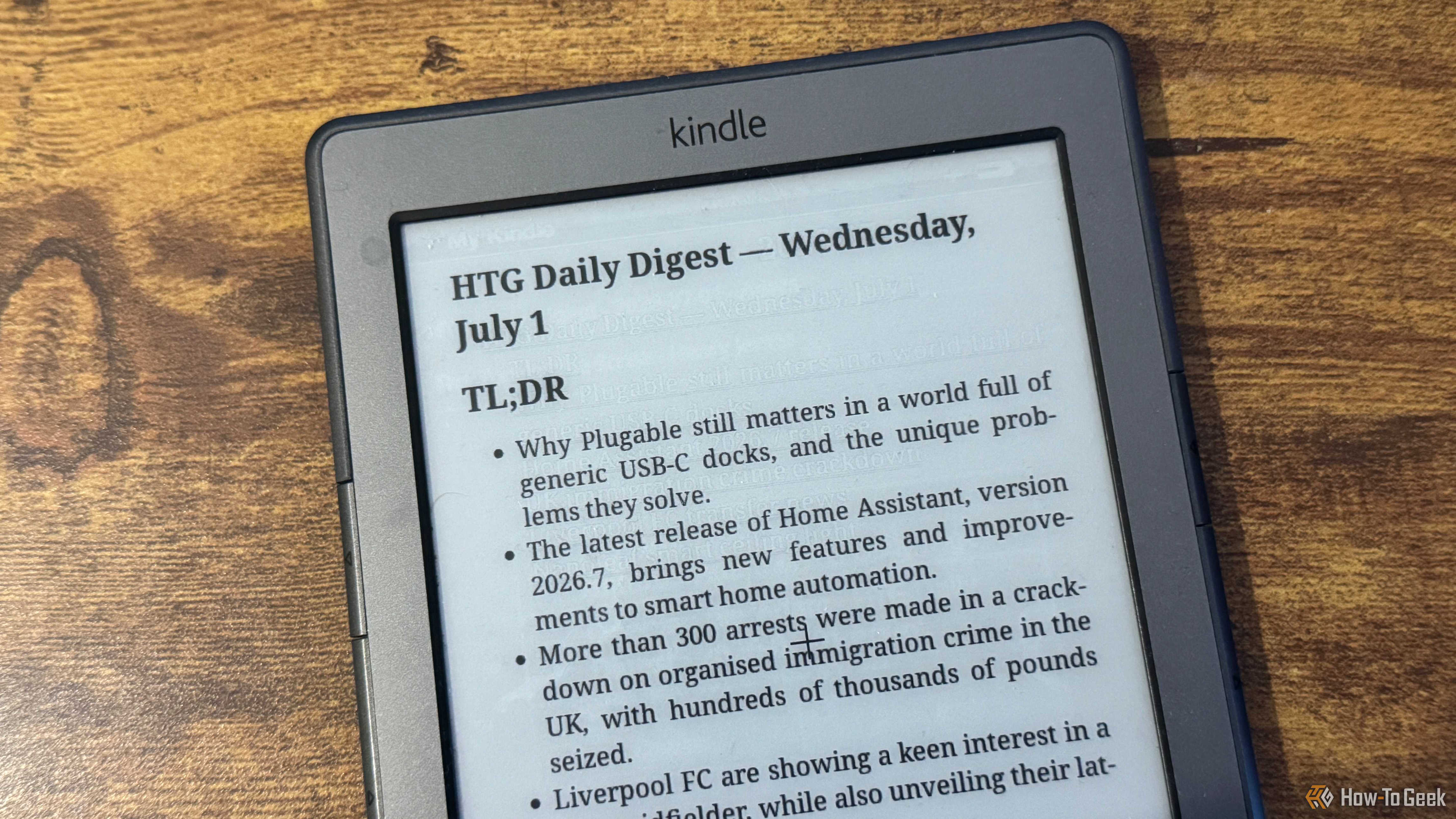 A close up of a Kindle 4 showing the HTG Daily Digest TLDR bullet list covering Plugable Home Assistant immigration crime and Liverpool FC.