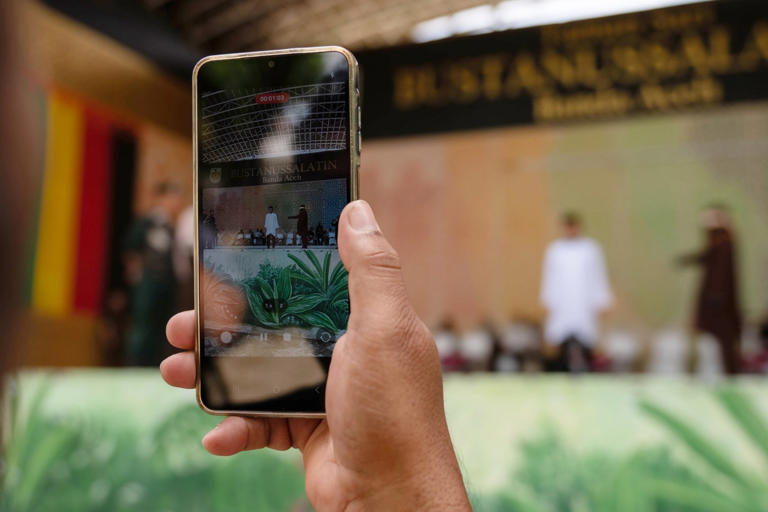 A man uses his phone to film a public caning in Banda Aceh earlier this month. Support for the punishment sometimes depends on the specific case. Photo: AP