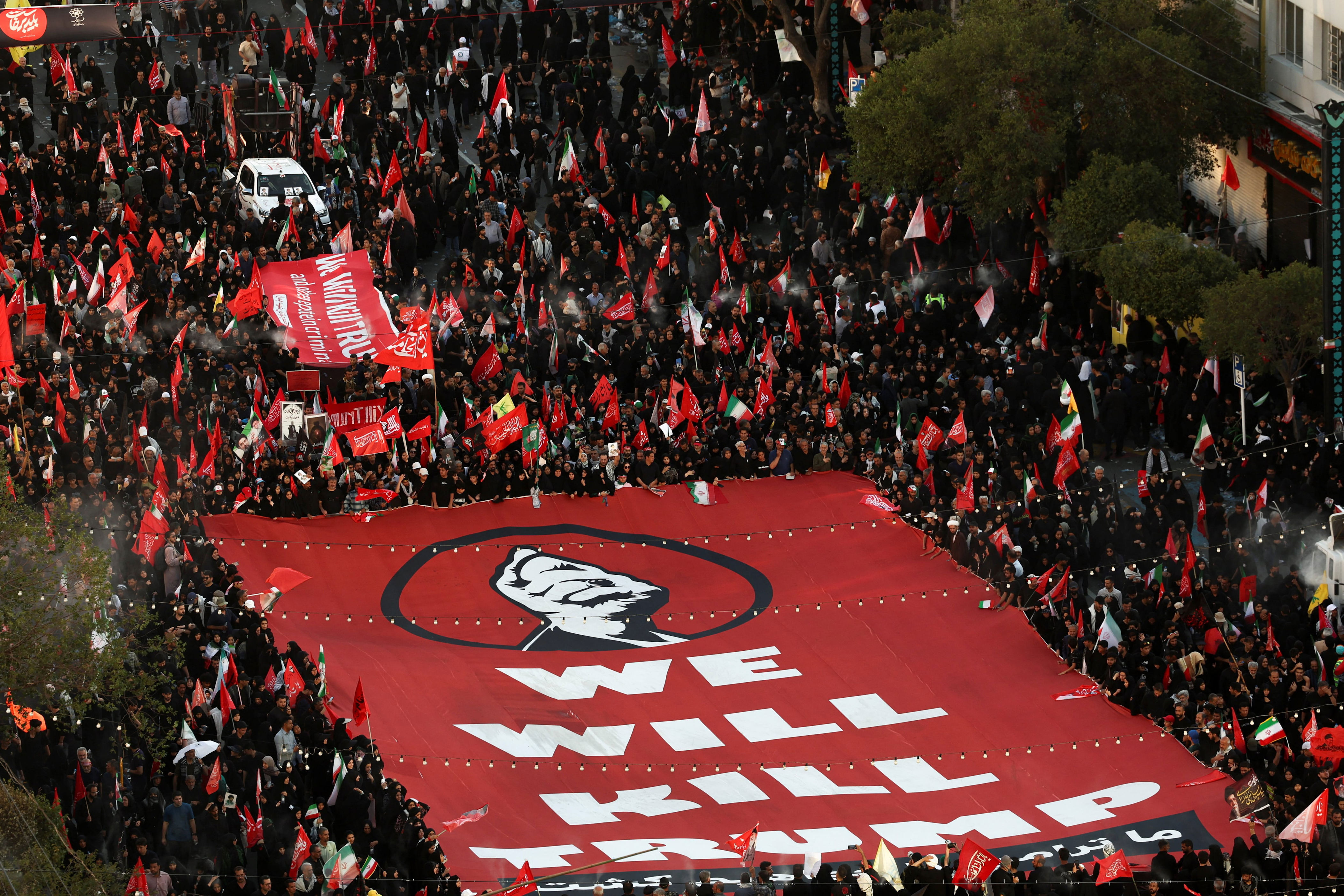 Iranian mourners carry a banner threatening Trump on the day of the burial of former Supreme Leader Ayatollah Ali Khamenei, who was killed on February 28 in Israeli and U.S. airstrikes. / Majid Asgaripour / via REUTERS