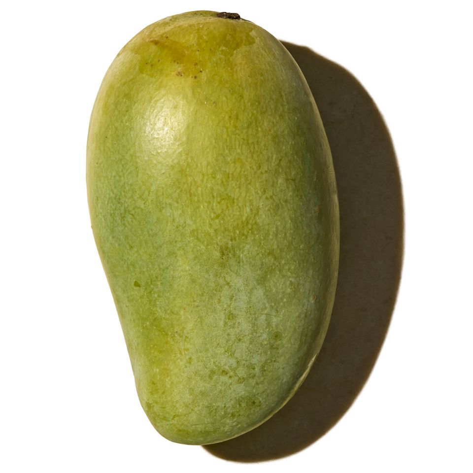 A single mango on a white background with a shadow cast to one side