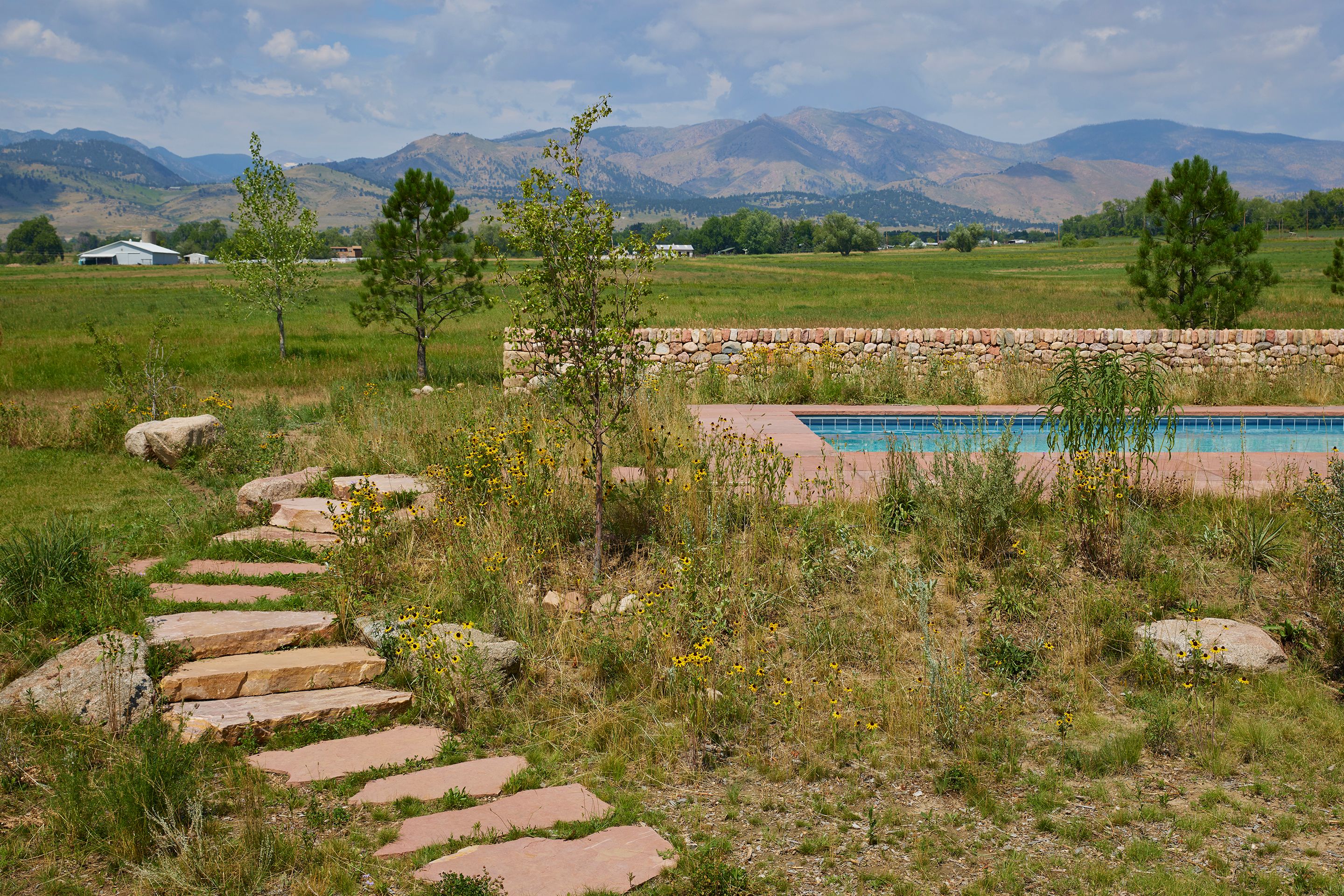 Around the pool are locally sourced Colorado red sandstone pavers and steps. In the backdrop are the picturesque Colorado mountain ranges.