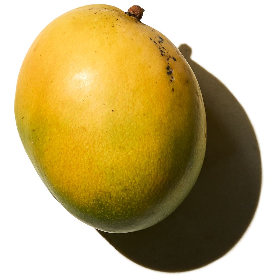 A mango placed against a white background creating a shadow