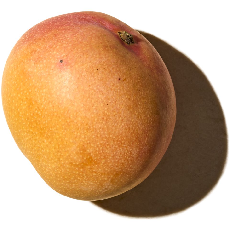 A mango casting a shadow on a white background
