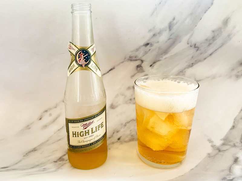 Bottle of Miller HIgh Life poured into glass of ice.