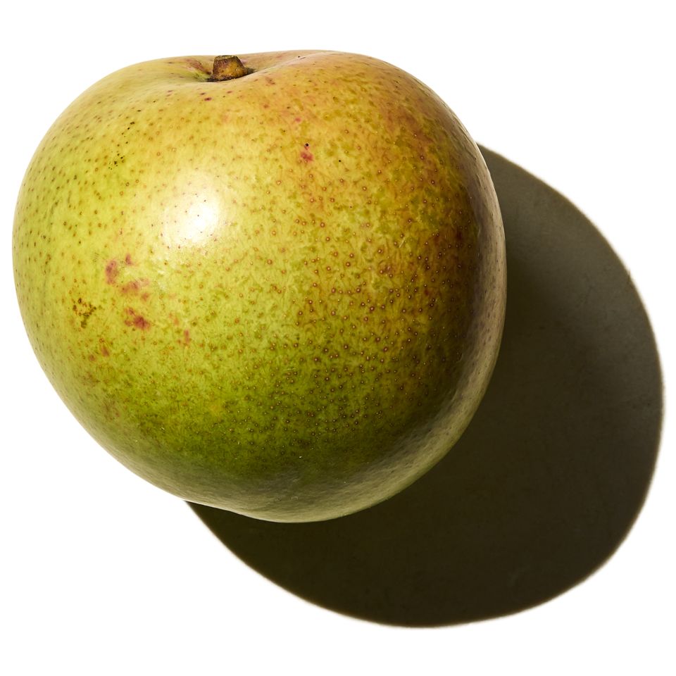 A single mango with its shadow on a white background