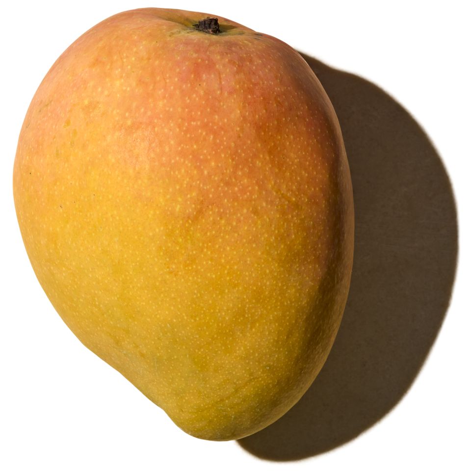 A single mango against a white background casting a shadow