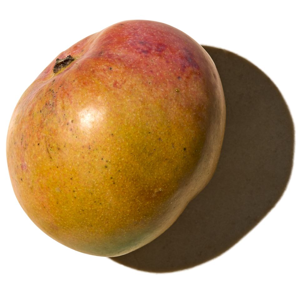 A mango with a shadow on a white background