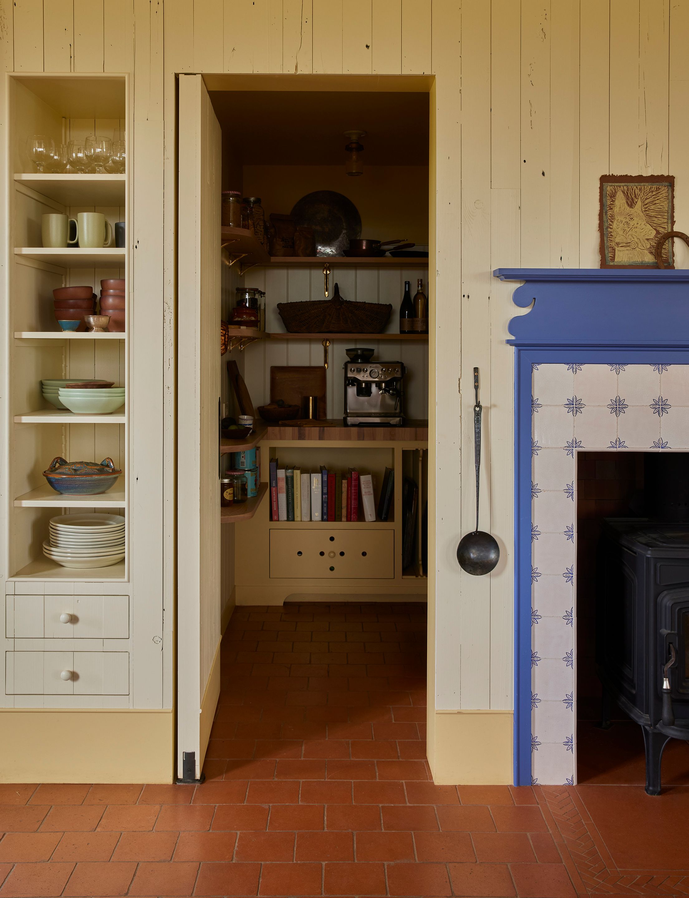 The pantry was designed as a slip of room without a window, nodding to a time before engineering optimized floor plans, and “you end up with these rooms in the middle of the house that don’t get any natural light,” says Menegat. In a busy house with two kids, animals, and lots of visitors, the pantry has become one of the client’s favorite rooms. “She’s like, I go down here before anybody’s awake and make coffee,” says Menegat. Alice’s Egg Spoon by the Permanent Collection hangs next to a custom mantel by Landed Interiors in Pitch Blue that surrounds Delft corner ornament leaf tiles by Douglas Watson Studio.