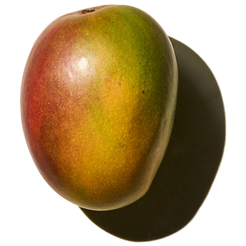 A single mango with a shadow on a white background